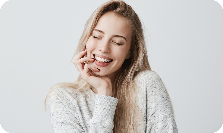 beautiful female closing eyes because joy with long blonde hair gentle smile cheerful woman holds hand chin has pleased expression face face expression positive